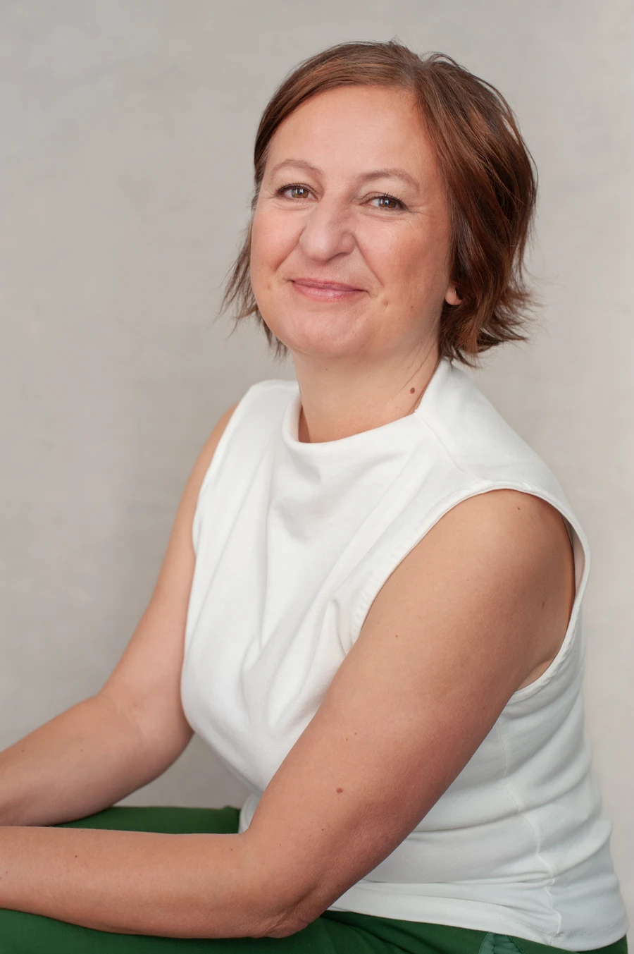Woman sitting on a chair smilling.